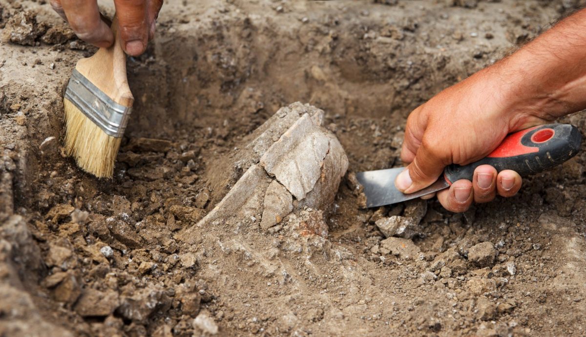 Eine archäologische Ausgrabung mit Pinsel und Spachtel.