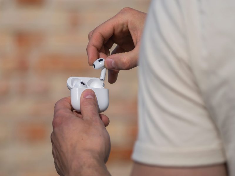 Mann steckt AirPods in ihre Halterung.