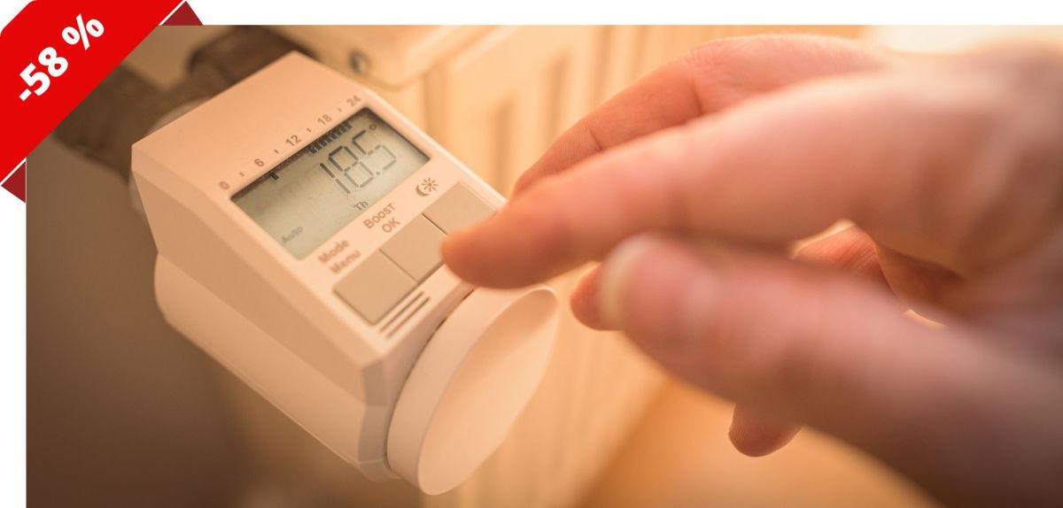 Finger tippt auf ein Heizkörperthermostat