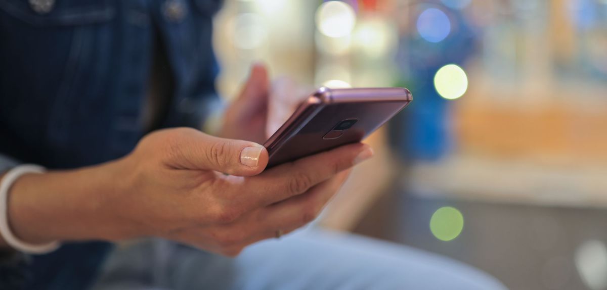 Person hält ein Smartphone in der Hand.