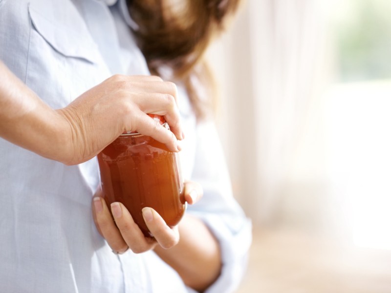 Frau versucht, ein Glas zu öffnen