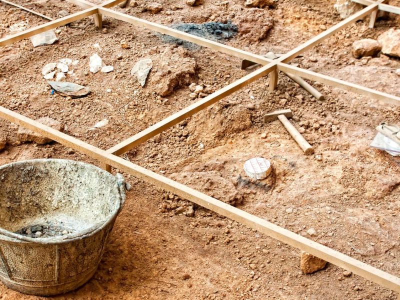 Mehrere archäologische Funde verstreut im Sand.