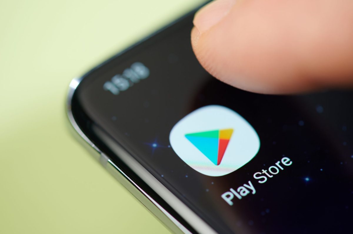 Google Play Store-Android-App wird auf einem Handy-Display angezeigt. Nahaufnahme auf einen Finger, der die App aufruft.