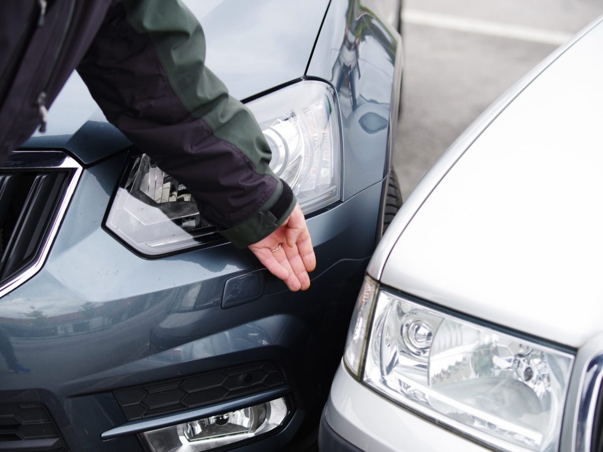 Person zeigt auf den Zusammenstoß zweier Autos