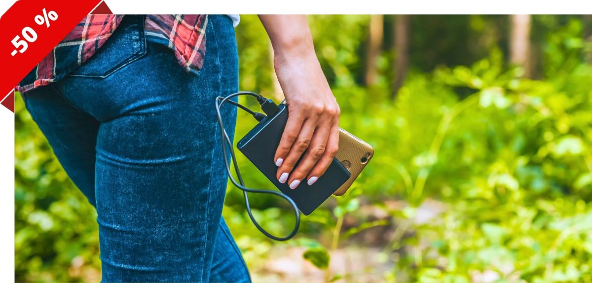 Person lÃ¤uft mit Powerbank und Smartphone durch einen Wald