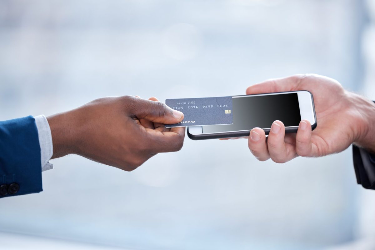 Eine Person hält eine Bankkarte über ein Handy.