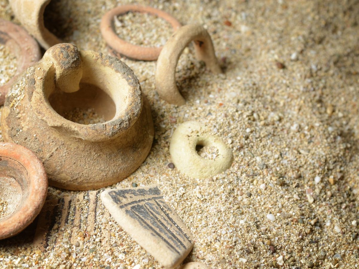 Archäologischer Fund aus Keramik im Sand.