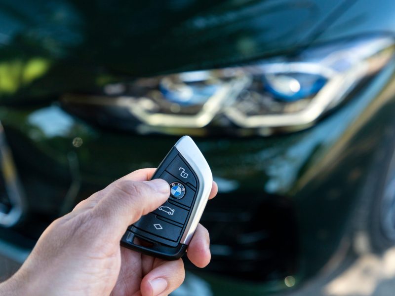 Person hält Autoschlüssel eines BMW in der Hand.