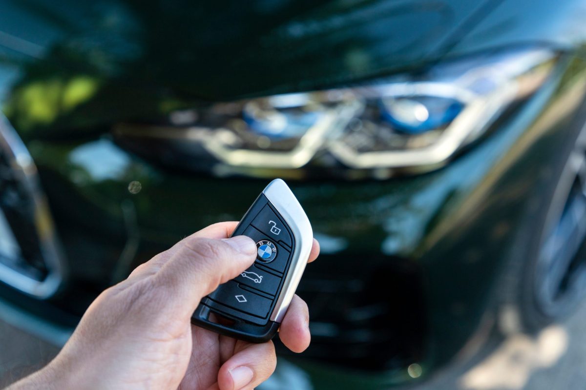 Person hält Autoschlüssel eines BMW in der Hand.