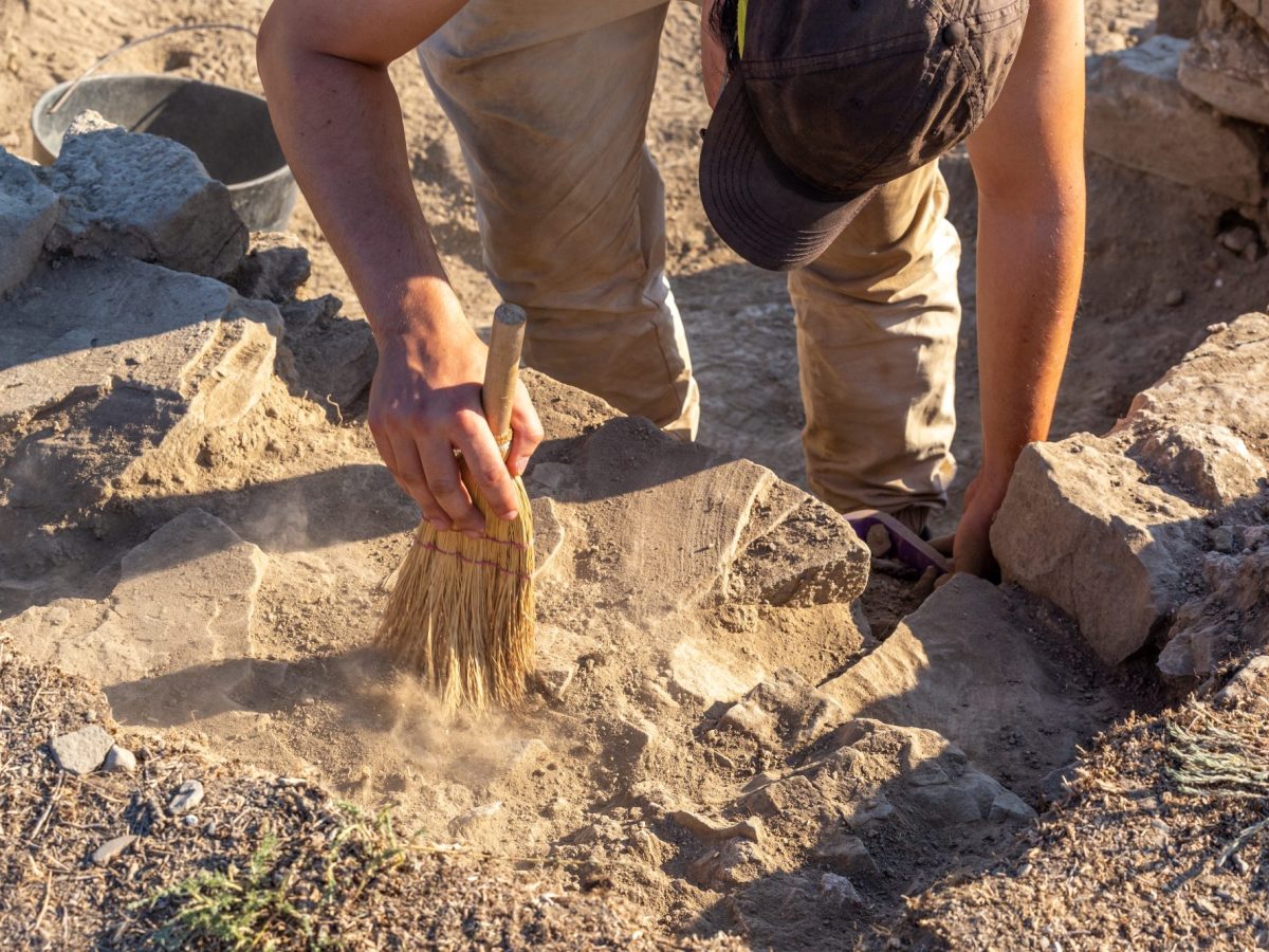 Mann gräbt an einem archäologischen Fund.