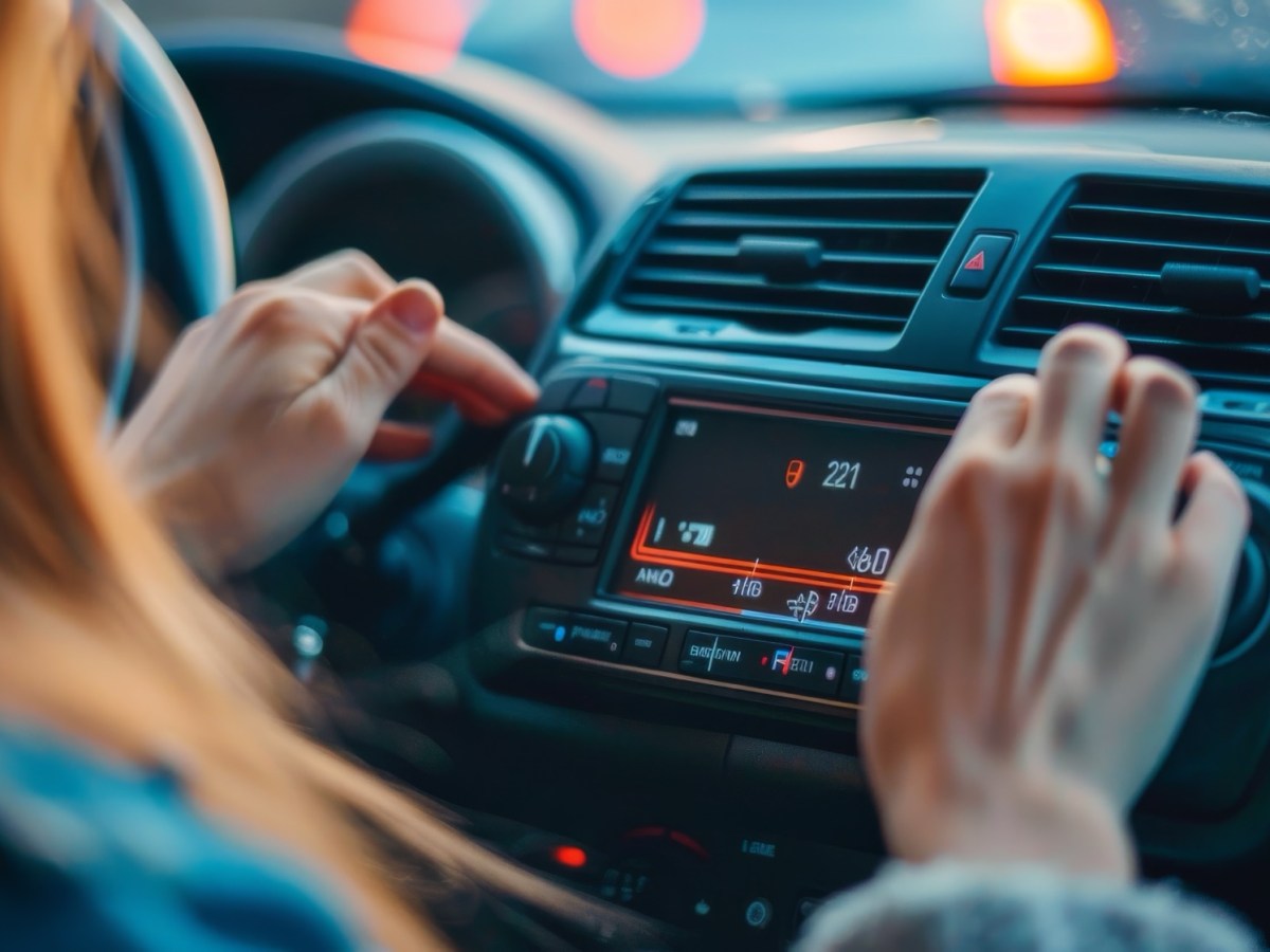 Frau stellt mehrere Knöpfe im Auto ein.