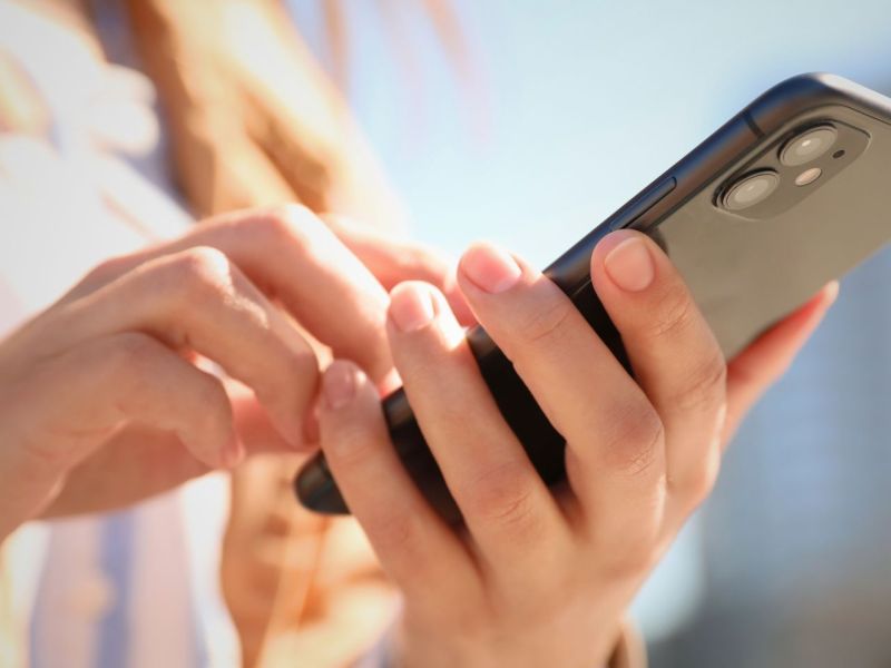 Frau hält iPhone 16 in der Hand.