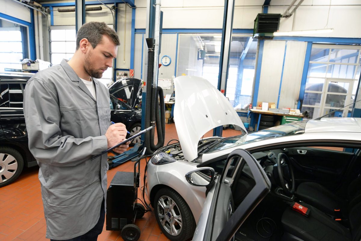 Fachmann prÃ¼ft beim TÃœV ein Auto.