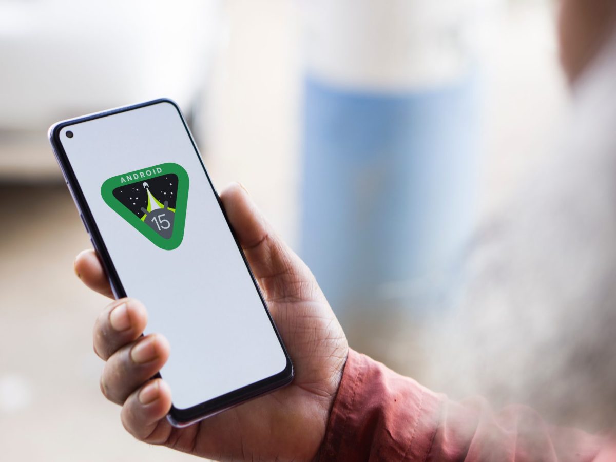 Eine Person hÃ¤lt ein Handy in der Hand. Auf dem Display wird das Android 15 Logo angezeigt.
