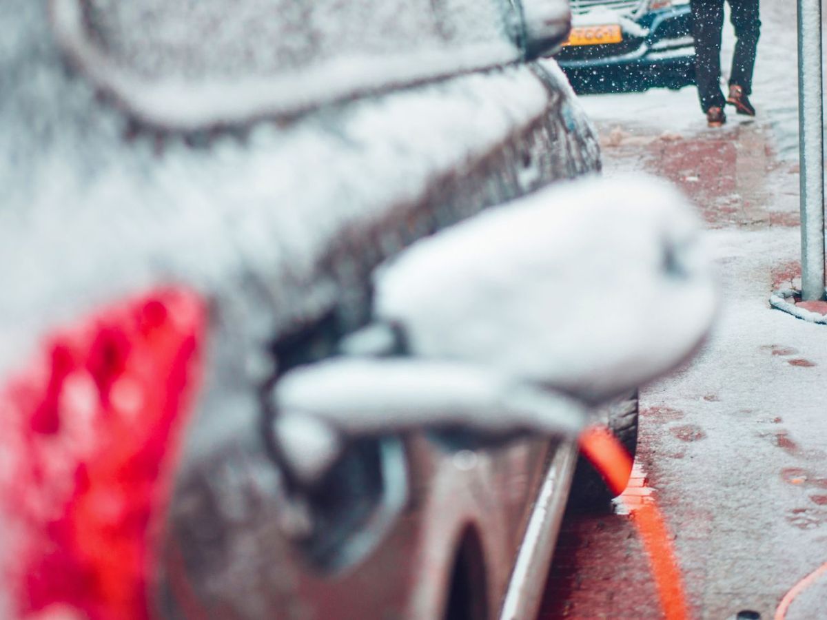 Schneebedecktes Elektroauto an einer LadesÃ¤ule