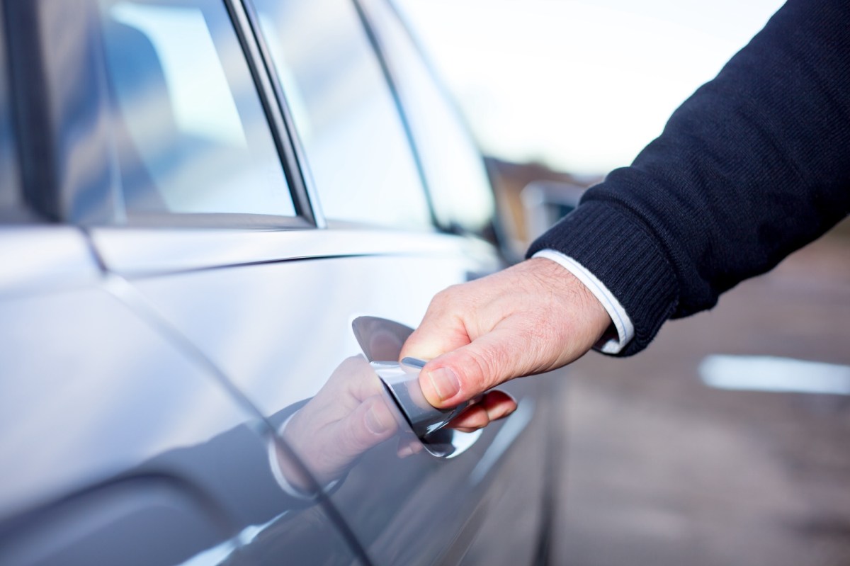 Mann öffnet die Tür am Auto