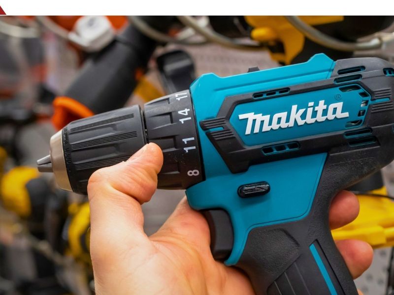 Person hält einen Akku-Schlagbohrschrauber von Makita in der Hand