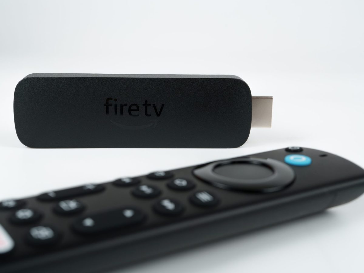 Amazon Fire TV Stick liegt neben einer Fernbedienung.