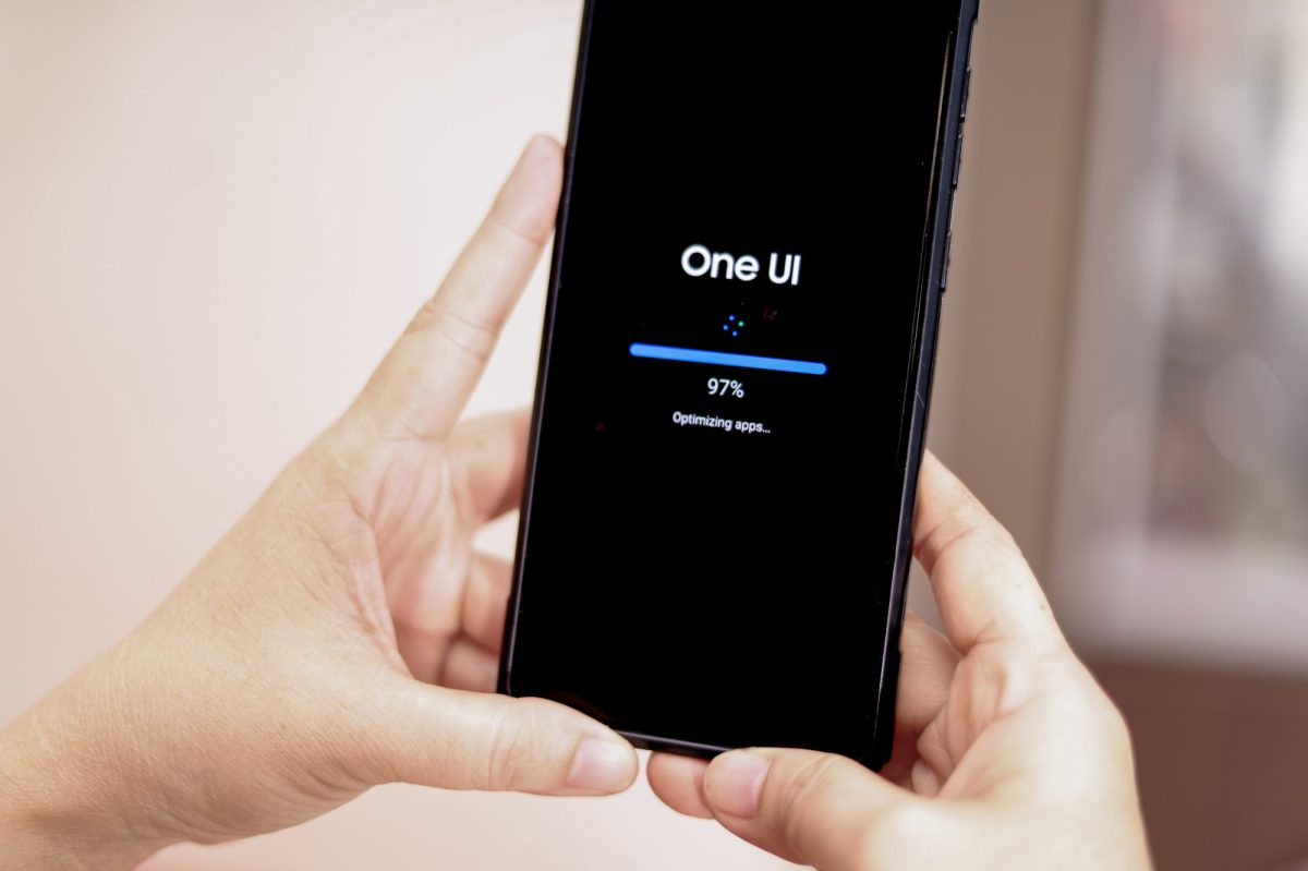 Person hält ein Handy in der Hand, auf dem ein Software-Update durchgeführt wird.