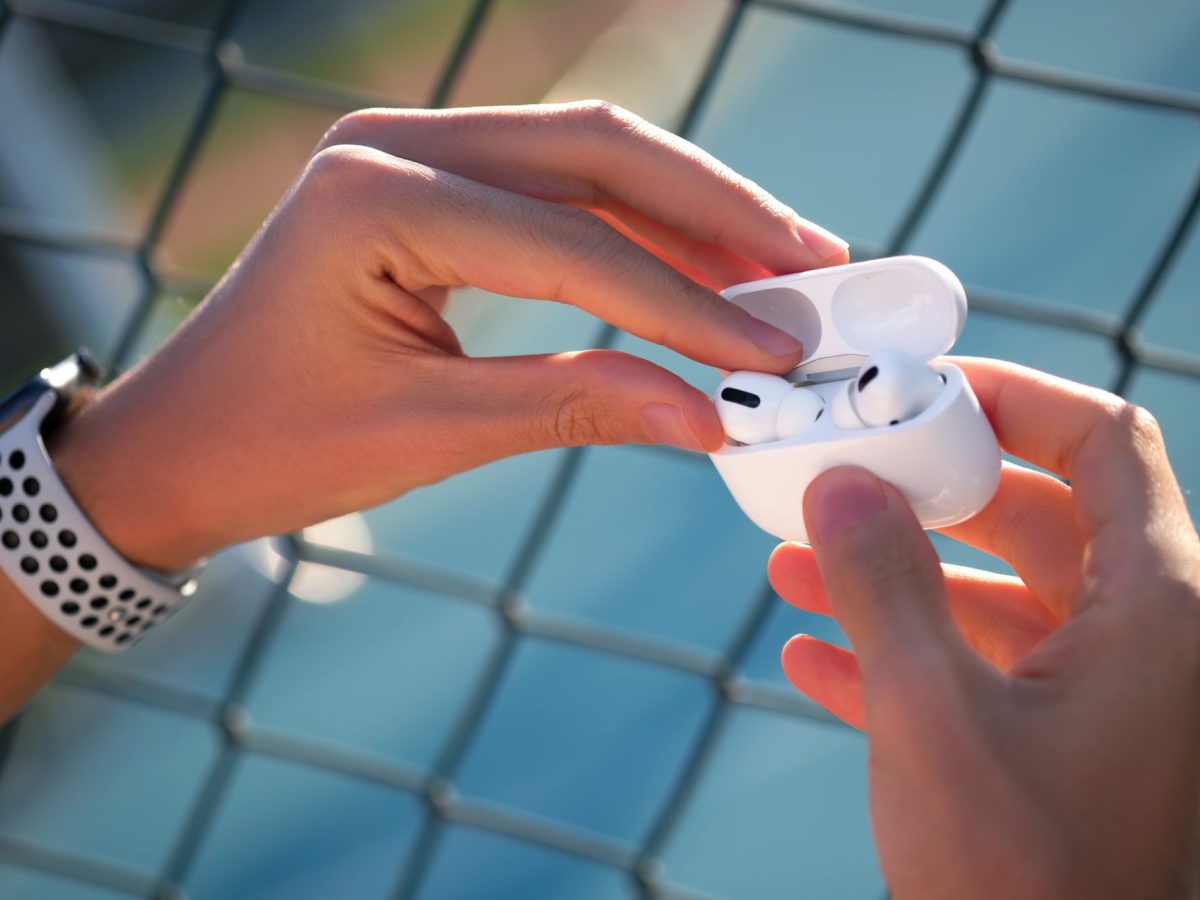 Person hÃ¤lt AirPods in der Hand.