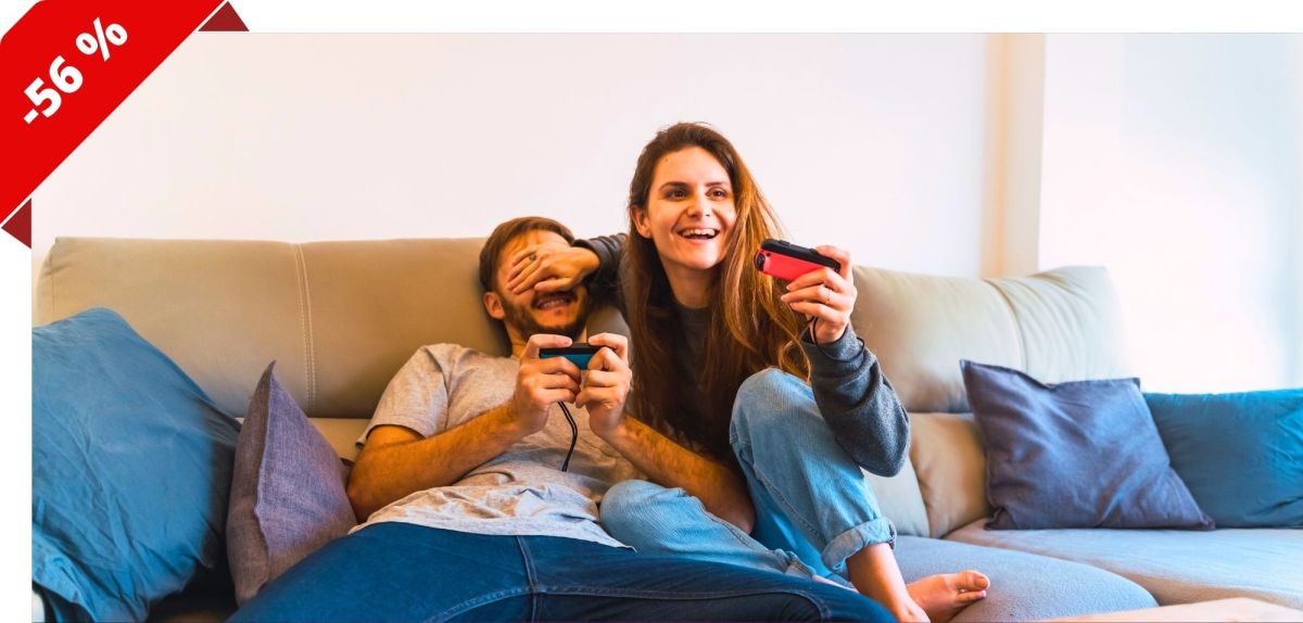 Mann und Frau sitzen auf einem Sofa und spielen mit einer Nintendo Switch