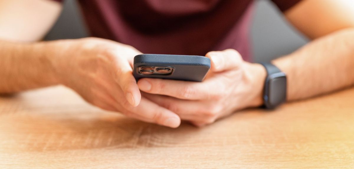 Mann mit iPhone in der Hand
