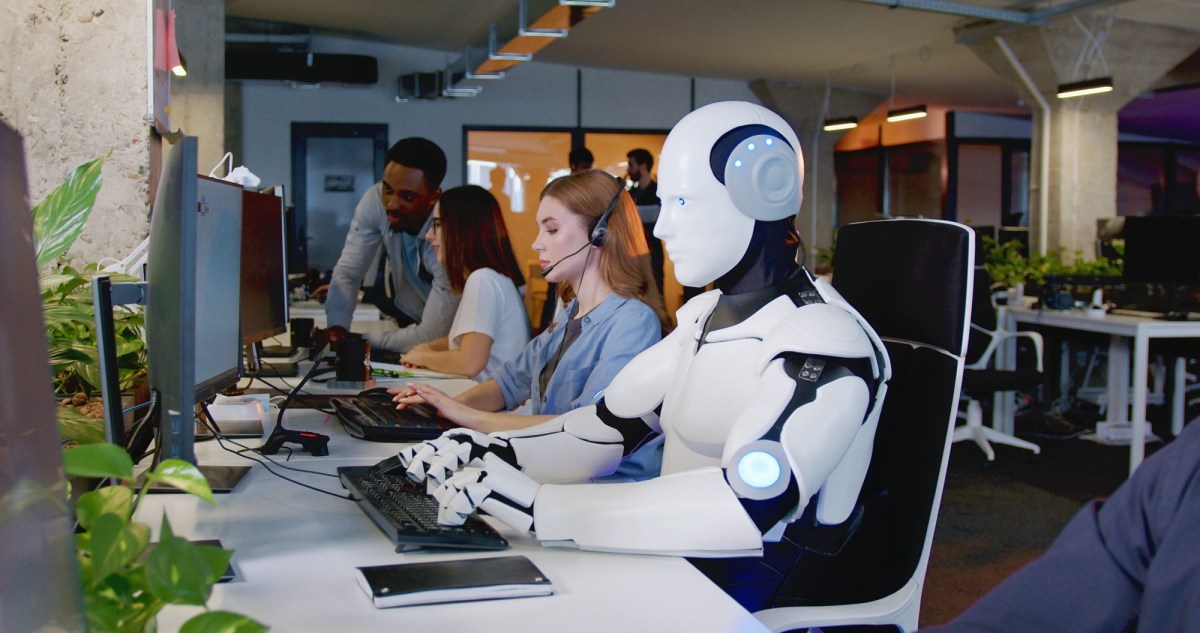 Roboter sitzt im Büro mit Menschen am Tisch