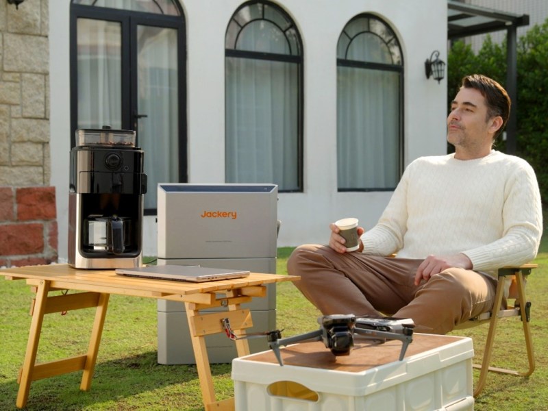 Mann sitzt neben einer Jackery HomePower 2000 Ultra im Garten