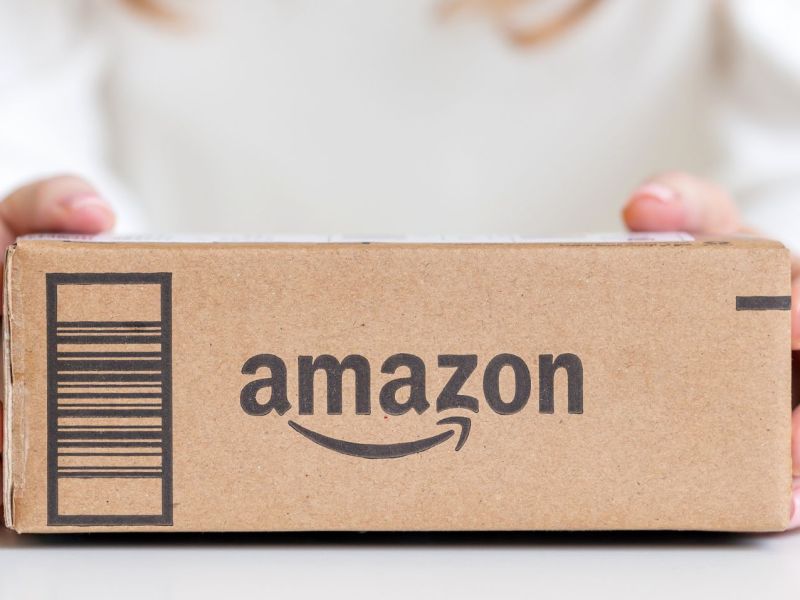 Frau hält ein Amazon-Paket in den Händen