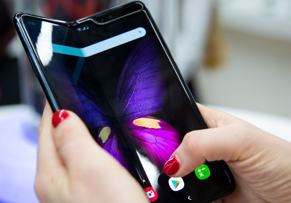 Person hält Handy mit Dual-Screen.